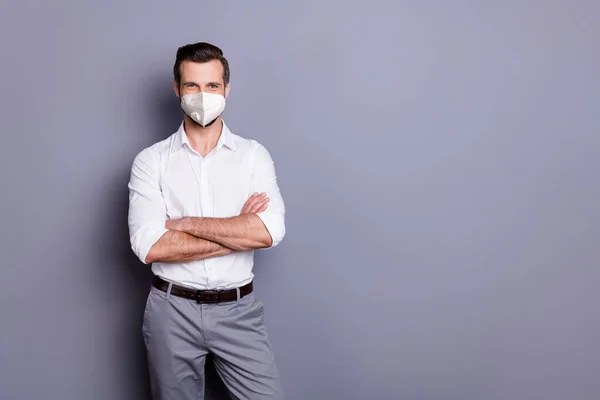 Portret van zijn hij aantrekkelijke gezonde succesvolle content guy werkgever dragen veiligheidsmasker gevouwen armen infectie griep porselein wuhan ziekte preventie sociale afstand geïsoleerde grijze kleur achtergrond — Stockfoto