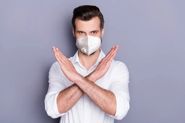 彼の魅力的な健康的な男を身に着けています安全マスクを身に着けている彼の魅力的な健康的な男は腕を越え呼吸器疾患メーカーは、灰色の色の背景に隔離されたウイルス性インフルエンザ流行をカバー — ストック写真