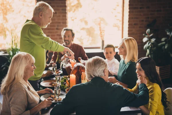 Portret van mooie aantrekkelijke zorgvuldige pleeggezin geadopteerd vrolijke familie zitten rond geserveerd tafel snijden binnenlandse kalkoen oogst herfst november op moderne zolder industriële baksteen interieur huis — Stockfoto