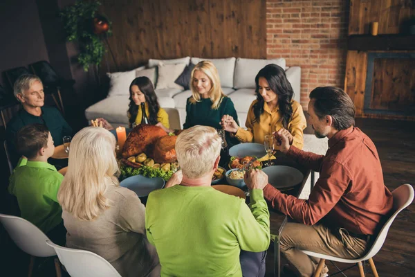 Portrait of nice attractive peaceful big full family meeting holding hands praying eating homemade domestic festal dishes luncheon at modern loft industrial brick interior house apartment — Stock Photo, Image