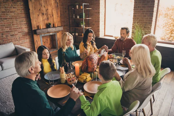 Foto da família completa oito membros reunindo sentar duas crianças pequenas segurar os olhos fechados rezar graças a Deus pratos de colheita ricos mesa de jantar multi-geração na sala de estar à noite dentro de casa — Fotografia de Stock