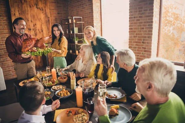 Portret van mooie aantrekkelijke vrolijke liefdevolle familie verzamelen huishoudster dragen bord verse zelfgemaakte kalkoen serveertafel tijd doorbrengen in moderne loft industriële baksteen interieur huis — Stockfoto