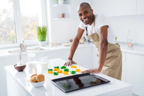 Foto de feliz cara afro-americano positivo fazendo cookies em casa — Fotografia de Stock