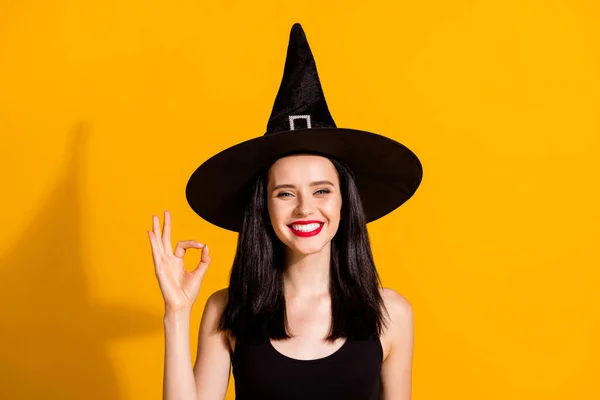 Foto de adorável bonito jovem mágico senhora dente sorrindo levantar mão mostrando okey cliente respondendo roupa de qualidade desgaste preto assistente headwear vestido isolado cor amarela brilhante fundo — Fotografia de Stock