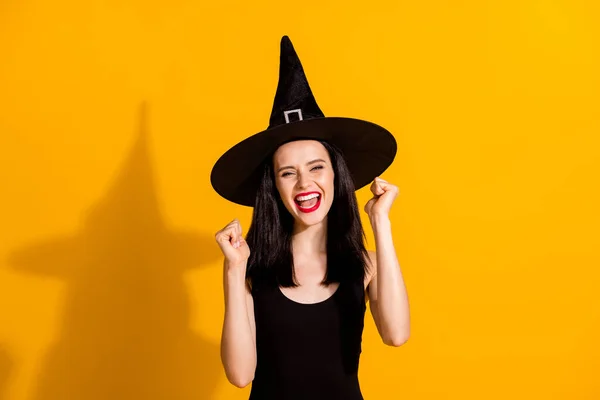 かなり美しい若い魔術師の女性の写真は、拳悲鳴を上げますええ勝利マスカレードクイズ興奮達成珍しい魔法アイテムは黒の帽子を着用ドレス孤立明るい黄色の色の背景 — ストック写真