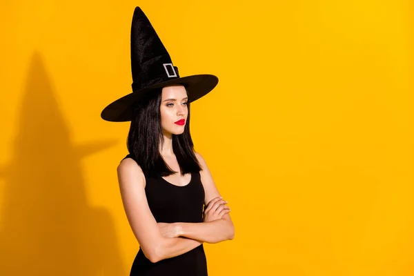 Profile photo of pretty lovely young sorceress lady crossed arms self-assured look empty space want turn everyone frog wear black headwear dress isolated bright yellow color background — Stock Photo, Image