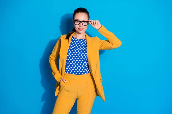 Фото привлекательной деловой леди успешный работник держать руку касание очки хорошее зрение носить желтый пиджак костюм пунктирная блузка рубашка изолированы ярко-синий цвет фона — стоковое фото