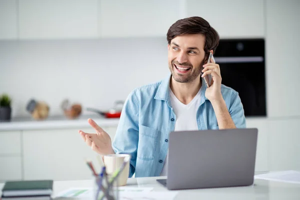 Foto van knappe student zakenman browsen notebook zittafel online conferentie goed humeur spreken telefoon collega 's partners gebaren handen sociale afstand quarantaine binnen — Stockfoto