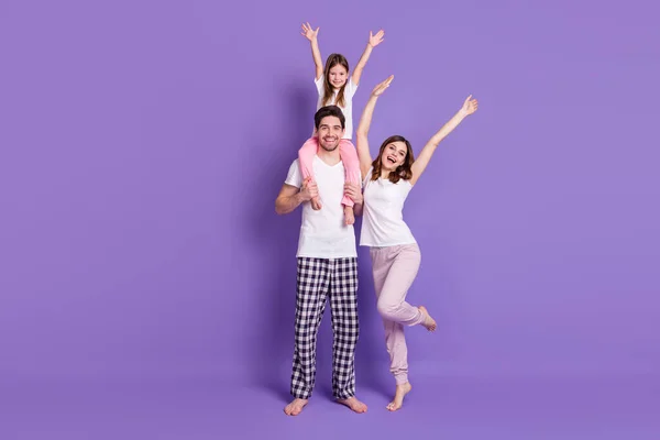 Full längd kroppsstorlek bild av tre personer glad familj pappa bär avkomma dotter bär pyjamas stigande händer upp ha kul helg isolerad ljus levande glans levande violett färg bakgrund — Stockfoto