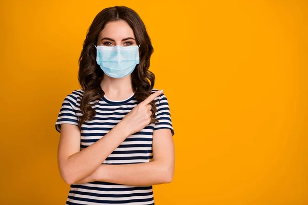 Close-up portrait of her she attractive content healthy wavy-haired girl wear safety gauze mask demonstrating copy space influenza pandemia isolated bright vivid shine vibrant yellow color background — Stock Photo, Image