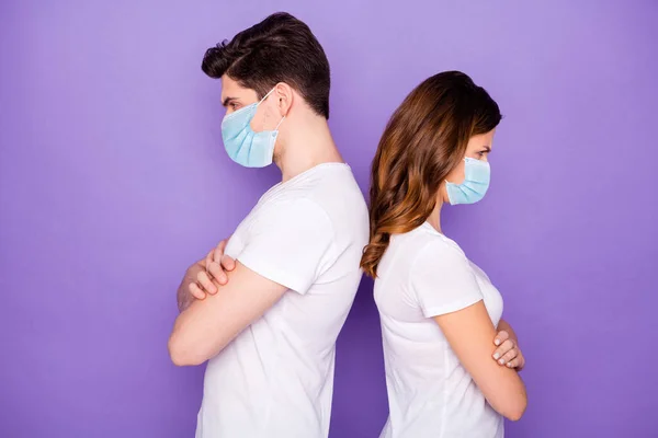 Profile side view portrait of his he her she offended sick ill unhealthy unwell couple folded arms wearing safety gauze mask mers cov social distance isolated purple violet pastel color background — Stock Photo, Image
