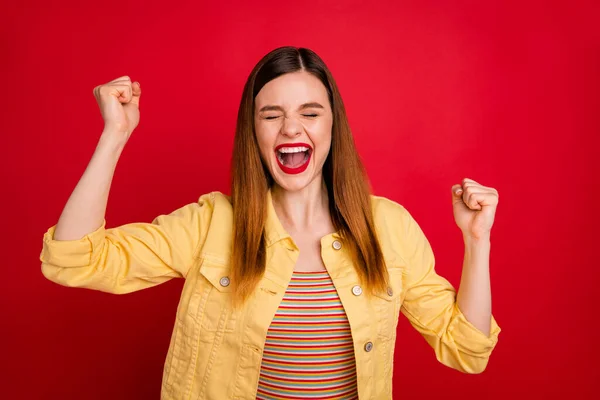 Foto van aantrekkelijke gekke dame goed humeur verheugen verhogen vuisten schreeuwen beste overwinning ooit ogen gesloten glorie moment dragen casual geel blazer jas geïsoleerde levendige rode kleur achtergrond — Stockfoto