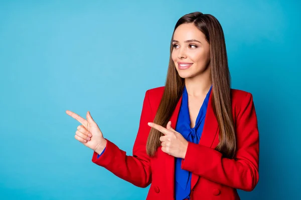 Foto de atractiva señora de negocios bastante sostenga los brazos dirigiendo los dedos laterales gerente de ventas de espacio vacío use pantalones de lujo rojo traje blusa aislado color azul fondo — Foto de Stock