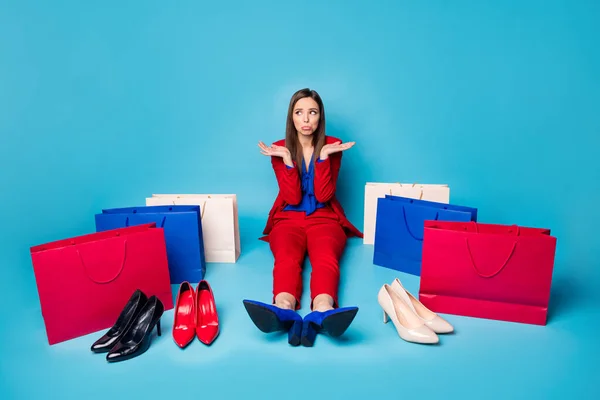 Full length photo of upset lady successful worker sit offended floor near shoes shopping bags difficult select wear red suit blouse blazer pants high-heels isolated blue color background