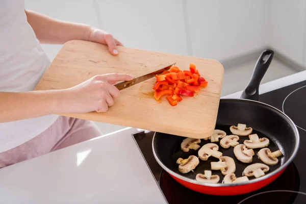 Gekropte bovenkant boven hoge hoek uitzicht foto van smakelijk ecologisch avondmaal voorbereiding vrouw voeg gehakte verse peper koekenpan paddestoel in huis keuken binnen — Stockfoto