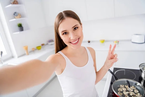 Tutup foto gadis positif koki gourmet lezat organik sehat eco vegetarian blogger mempersiapkan resep makan malam membuat selfie v-sign memakai singlet putih-top di dapur rumah dalam ruangan — Stok Foto