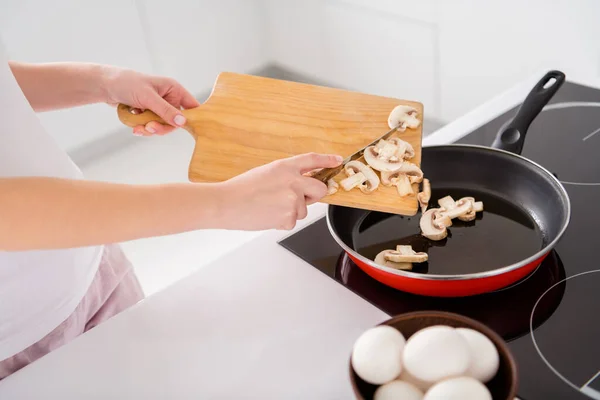 Gekropte top boven hoge hoek foto van gastronomisch smakelijk avondmaal menu voorbereiding vrouw voeg champignons koekenpan snijplank in huis binnen — Stockfoto