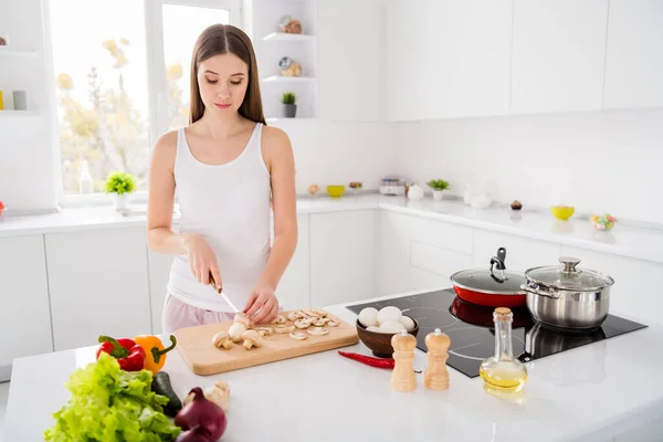 Foto van gericht gastronomisch chef-kok meisje bereiden smakelijke ecologische biologische menu avondeten snijmes houten snijplank paddenstoelen op tafel in keuken huis binnen — Stockfoto