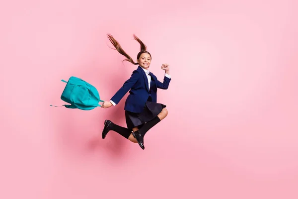 フル長さボディサイズプロフィール側ビューの魅力的なやる気スマートで陽気な小さな女の子ジャンプ摩耗靴下歩行者を運ぶ青バッグラッシュ隔離されたピンクパステルカラー背景 — ストック写真