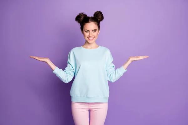 Portré pozitív magabiztos ifjúsági lány promoter tartsa a kezét jelen tárgy hirdetések promóciós viselni jó megjelenés ruha nadrág elszigetelt felett lila szín háttér — Stock Fotó