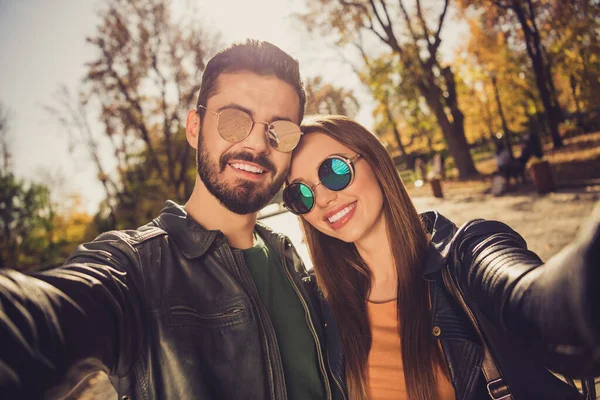 Retrato de positivo dois hipsters menina cara fazer selfie no amarelo floresta outono parque desgaste casual jaqueta — Fotografia de Stock