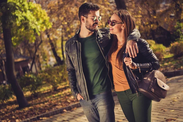 Foto de chico hipsters positivos abrazar a su novia en amarillo octubre bosque ciudad parque llevar mochila —  Fotos de Stock