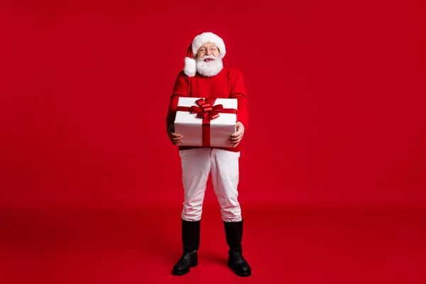 Noel Baba başlıklı pozitif yaşlı adamın tam boy fotoğrafı. Noel perisi için büyük bir hediye kutusu tutun. Neşeli, büyülü bir kutlama. — Stok fotoğraf
