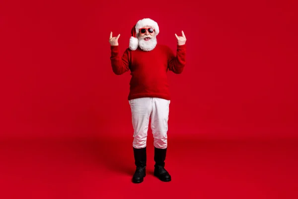 Ganzkörper-Foto lustig verrückt alter Mann Weihnachtsmann Weihnachtsmann Kopfbedeckung zeigen gehörnte Symbol Neujahr Rock Roll Heavy Metal X-mas Veranstaltung tragen Stiefel Pullover Hose isoliert hellen Glanz Farbe Hintergrund — Stockfoto