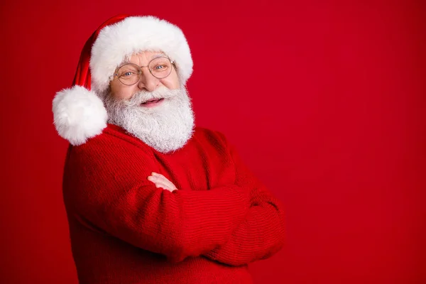 Turned photo of positive old retire pensioner man in santa claus hat cross hands enjoy fairy magic miracle advent event wear sweater isolated over bright shine color background — Stock Photo, Image