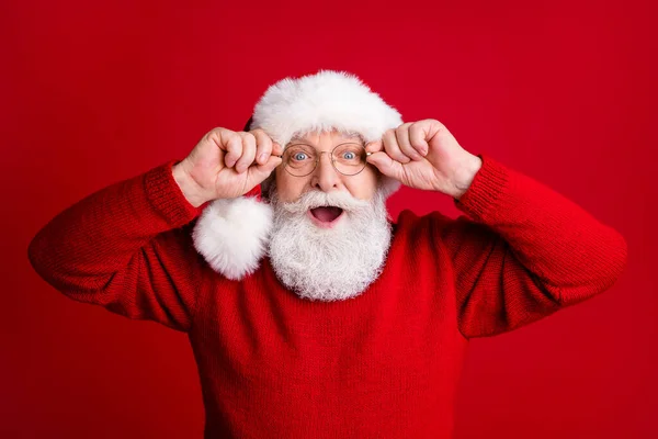 Foto van verrast geschokt oude man in kerstman hoed genieten van vreugde winter nieuwjaar noel kortingen aanraken glas slijtage glans jumper geïsoleerd over heldere kleur achtergrond — Stockfoto