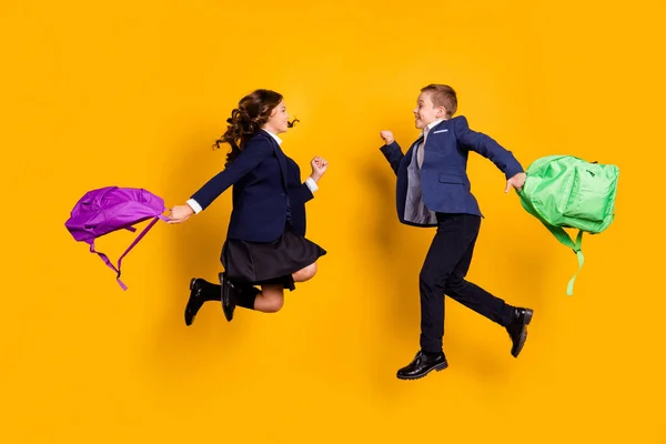 Longitud completa cuerpo tamaño vista de su ella ella atractiva poco alegre niños saltando de nuevo a la escuela celebrando el nuevo año académico aislado brillante brillo vivo vibrante color amarillo fondo — Foto de Stock