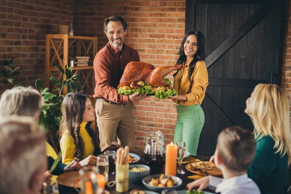 Young marriage parents hold decorated apples stuffed big turkey holiday dinner family reunion living room indoors — Stock Photo, Image