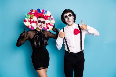Photo of spooky two people man lady show raise thumb up approve undead local tavern carnival wear black short mini dress death costume rose headband suspenders isolated blue color background clipart