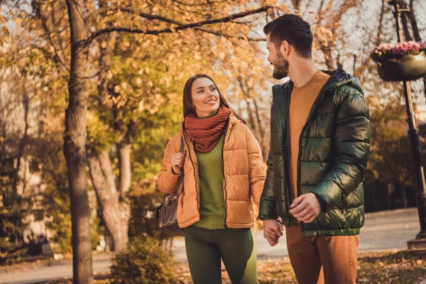 Foto de positivo encantador casal passeio no outono floresta cidade centro parque segurar as mãos usar jaquetas mochila — Fotografia de Stock