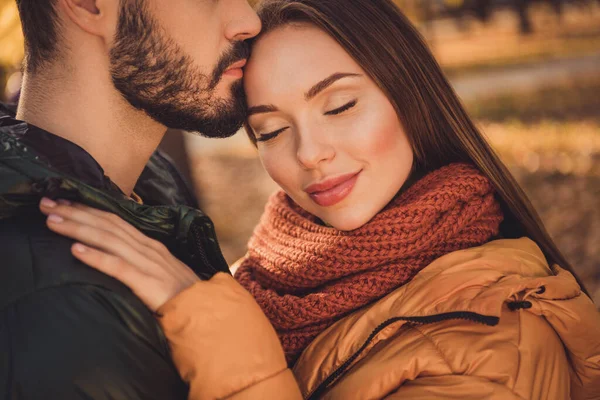 Beskuren närbild foto av tillgiven par kille kyss pannan själsfrände flickvän bära halsduk i höst september park — Stockfoto