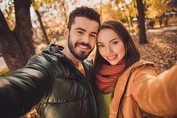 Portret namiętnej więzi para dziewczyna facet zrobić selfie jesienią park zużycie październik płaszcze — Zdjęcie stockowe