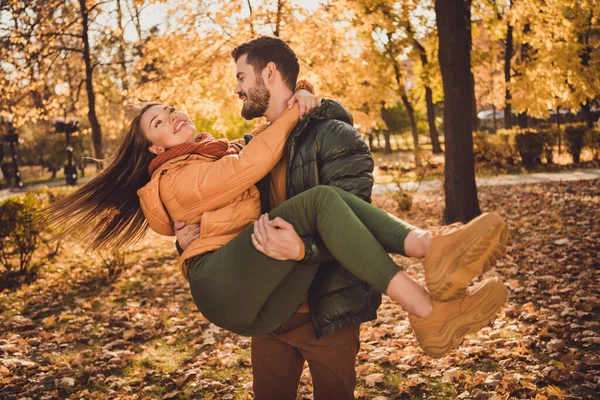 Foto de pareja cariñosa chico mantenga a la novia alma gemela en otoño septiembre amarillo ciudad parque desgaste chaqueta de temporada — Foto de Stock
