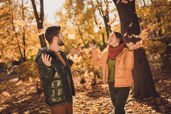 Foto av positiva glada två personer flicka kille kasta lönn september löv skratta i staden hösten utanför park — Stockfoto
