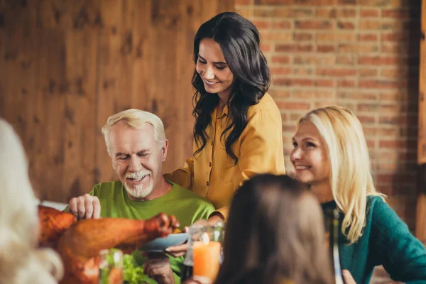 Familie reünie jonge generatie verzorgen van de oude generatie vieren Thanksgiving eten eettafel huis woonkamer binnen — Stockfoto