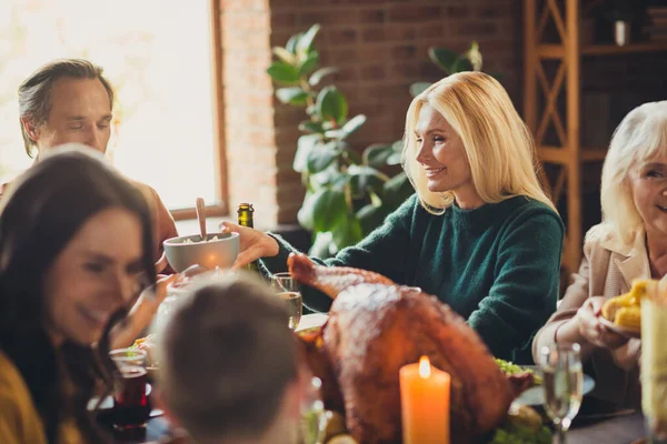 Photo of full family gathering thanksgiving feast served dinner chatting starting meal house evening living room indoors