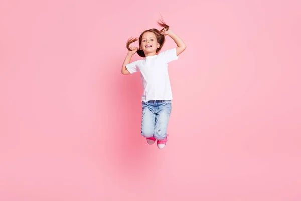 Seidig glatte Friseursalon Therapie gut sogar Kinder Anzeigen Konzept, Ganzkörper-Foto von schönen Kind Mädchen springen halten Hände ihr Haar tragen Denim weißes T-Shirt isoliert pastellfarbenen Hintergrund — Stockfoto