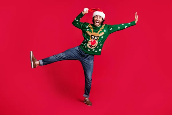Tampilan panjang badan penuh komik kekanak-kanakan lucu gembira pria latin hispanik yang ceria mengenakan topi Santa menari bersenang-senang membodohi terang terisolasi bersinar cerah latar belakang warna merah bersemangat — Stok Foto