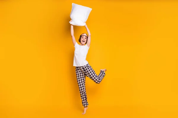 Full length body size view of her she nice attractive lovely carefree cheerful cheery girl jumping having fun holding in hand white pillow isolated bright vivid shine vibrant yellow color background — Stock Photo, Image