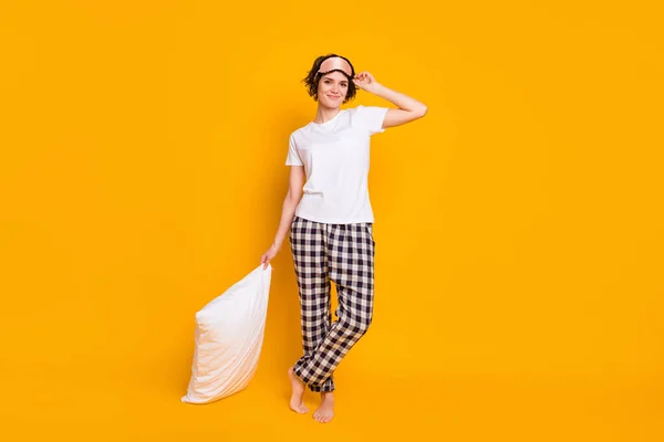 Full length photo of cute pretty girl hold soft pillow ready healthy sleep wear pants t-shirt eye mask isolated over vibrant color background