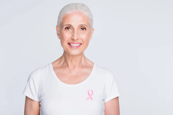 De cerca la foto de la encantadora dama mirando a la cámara sosteniendo el símbolo rosa en su elegante camiseta aislada sobre fondo blanco — Foto de Stock