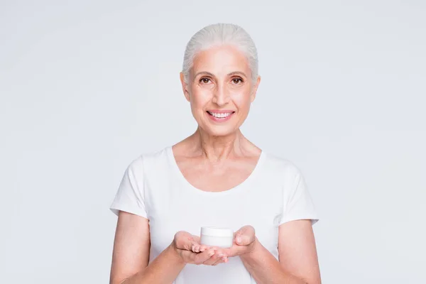 Porträt des charmanten Rentners in stilvollem, trendigem T-Shirt mit Lotion isoliert über weißem T-Shirt isoliert über weißem Hintergrund — Stockfoto