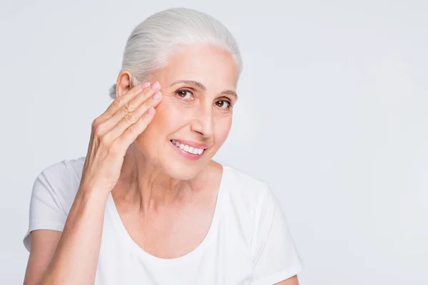 Close-up retrato dela ela agradável-olhando atraente adorável alegre conteúdo suave alegre senhora de cabelos grisalhos tocando fresco elástico pele facial contorno isolado no fundo cinza branco claro — Fotografia de Stock