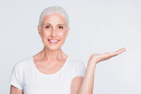 Primer plano retrato de ella ella agradable atractivo alegre alegre alegre confiada dama de pelo gris sosteniendo en la palma ad nuevo regalo novedad sorpresa presente aislado sobre fondo gris blanco claro — Foto de Stock