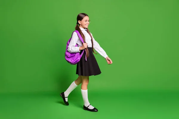 Foto ritratto di ragazza che cammina in avanti con borsa rosa su una spalla isolata su sfondo verde vivido — Foto Stock