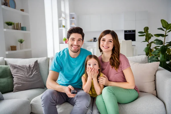 Foto de tres personas mamá papá niño niña sentarse comodidad sofá interruptor canal control remoto tienen descanso ver la televisión en casa en interiores — Foto de Stock